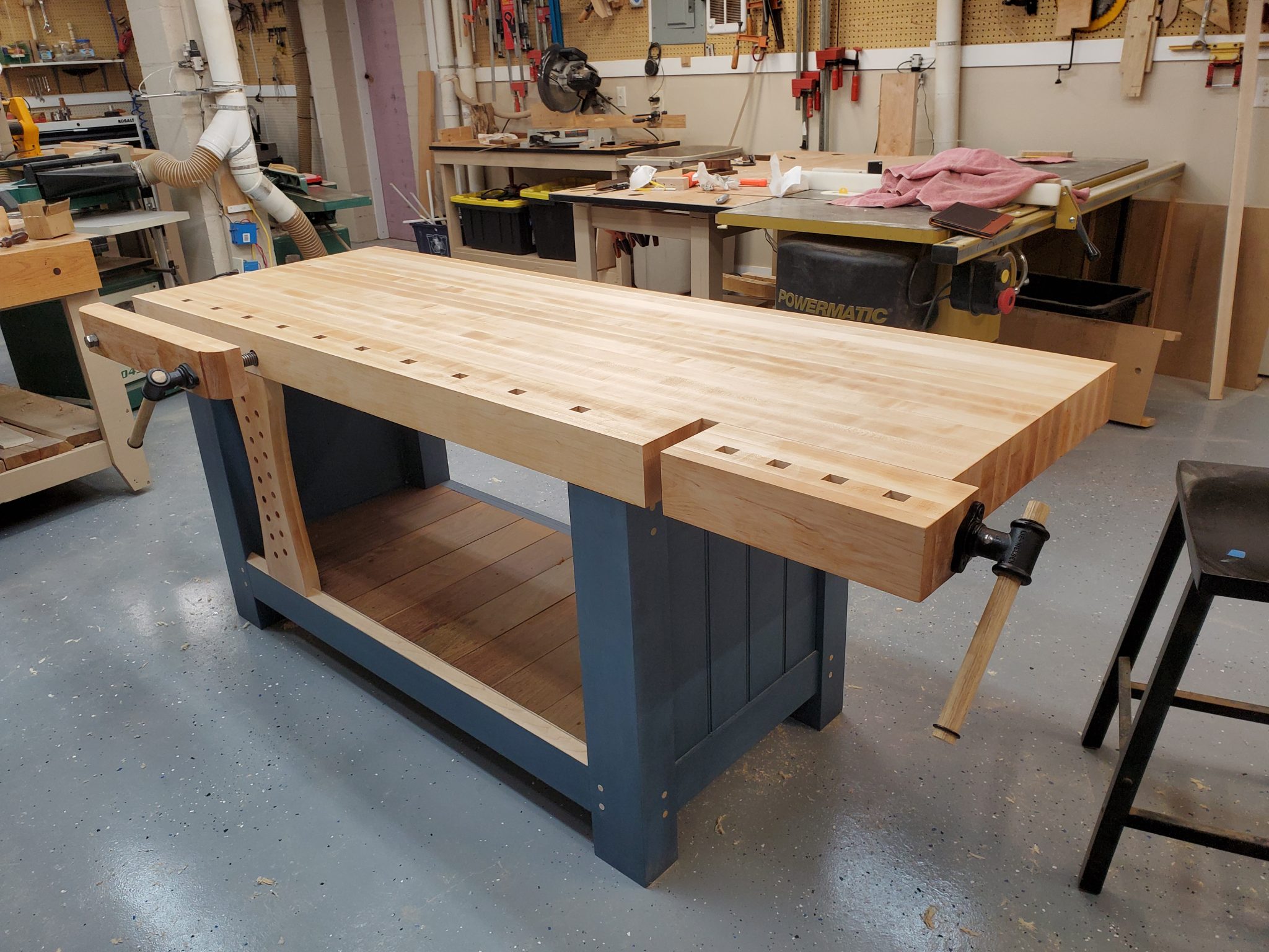 Shaker inspired work bench with end and twin screw vise.  Maple with milk painted base